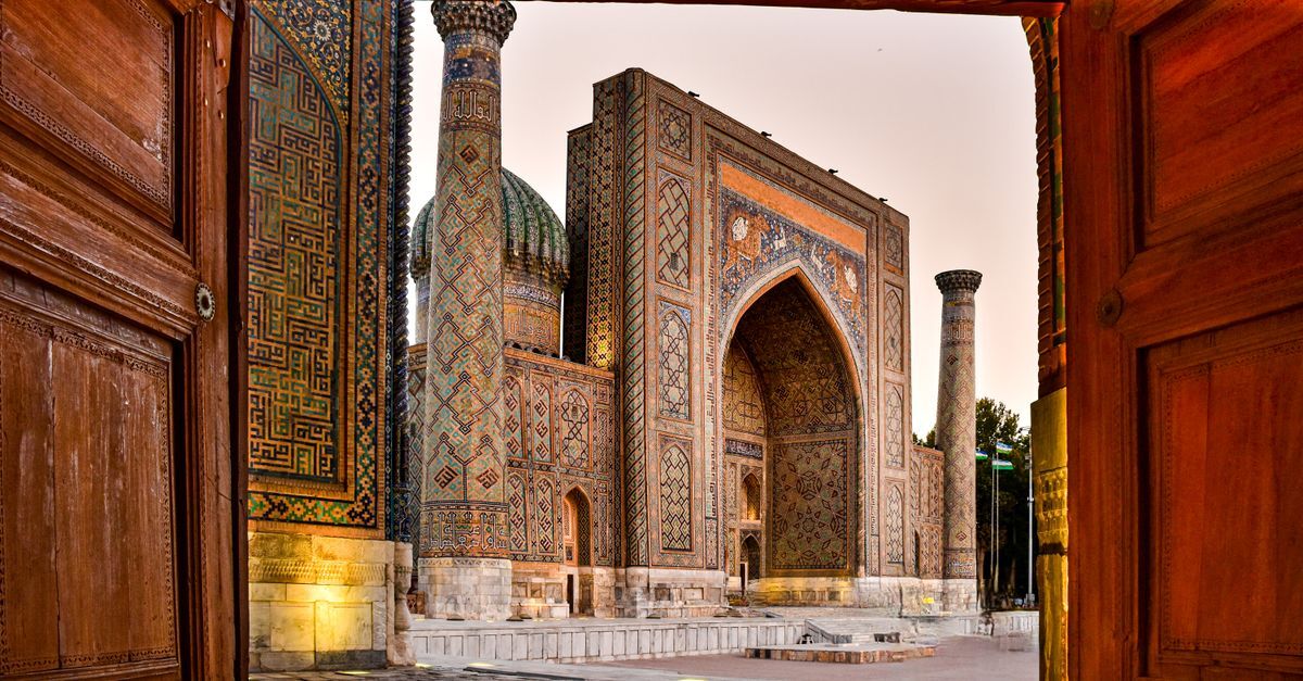 Registan Square in Samarkand beneath a pink evening sky