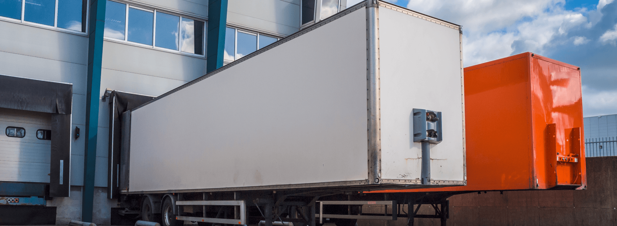 Два логистических вагона припаркованы у здания