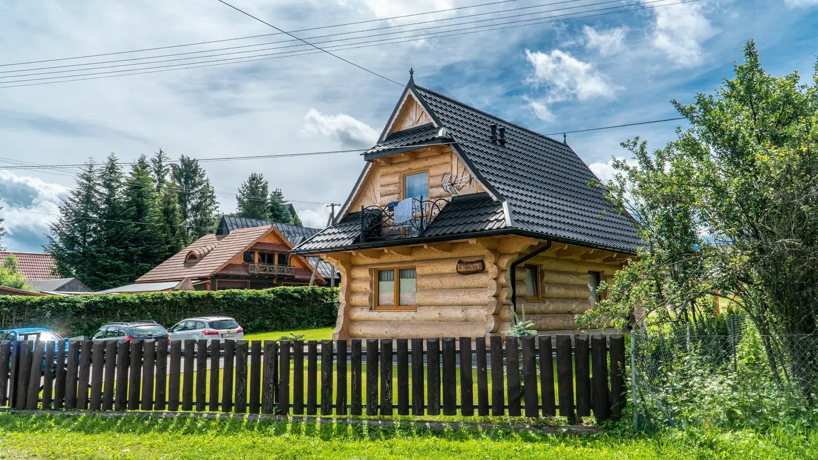 Бревенчатый дом с тёмной кровлей Venecja, вид со стороны улицы