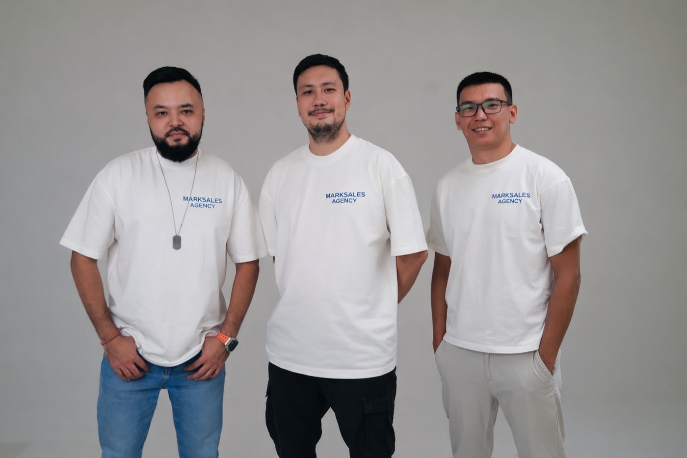 Команда Marksales Agency в футболках с логотипом на сером фоне