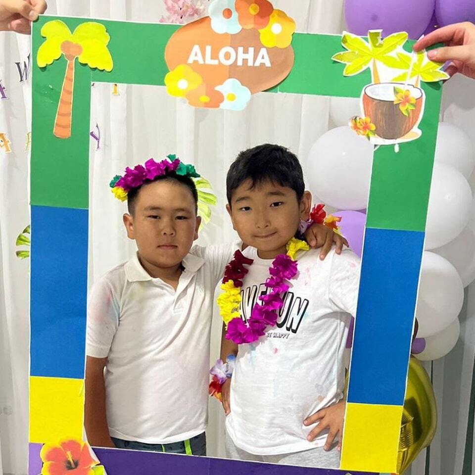 Дети фотографируются на тематической вечеринке в гавайском стиле
