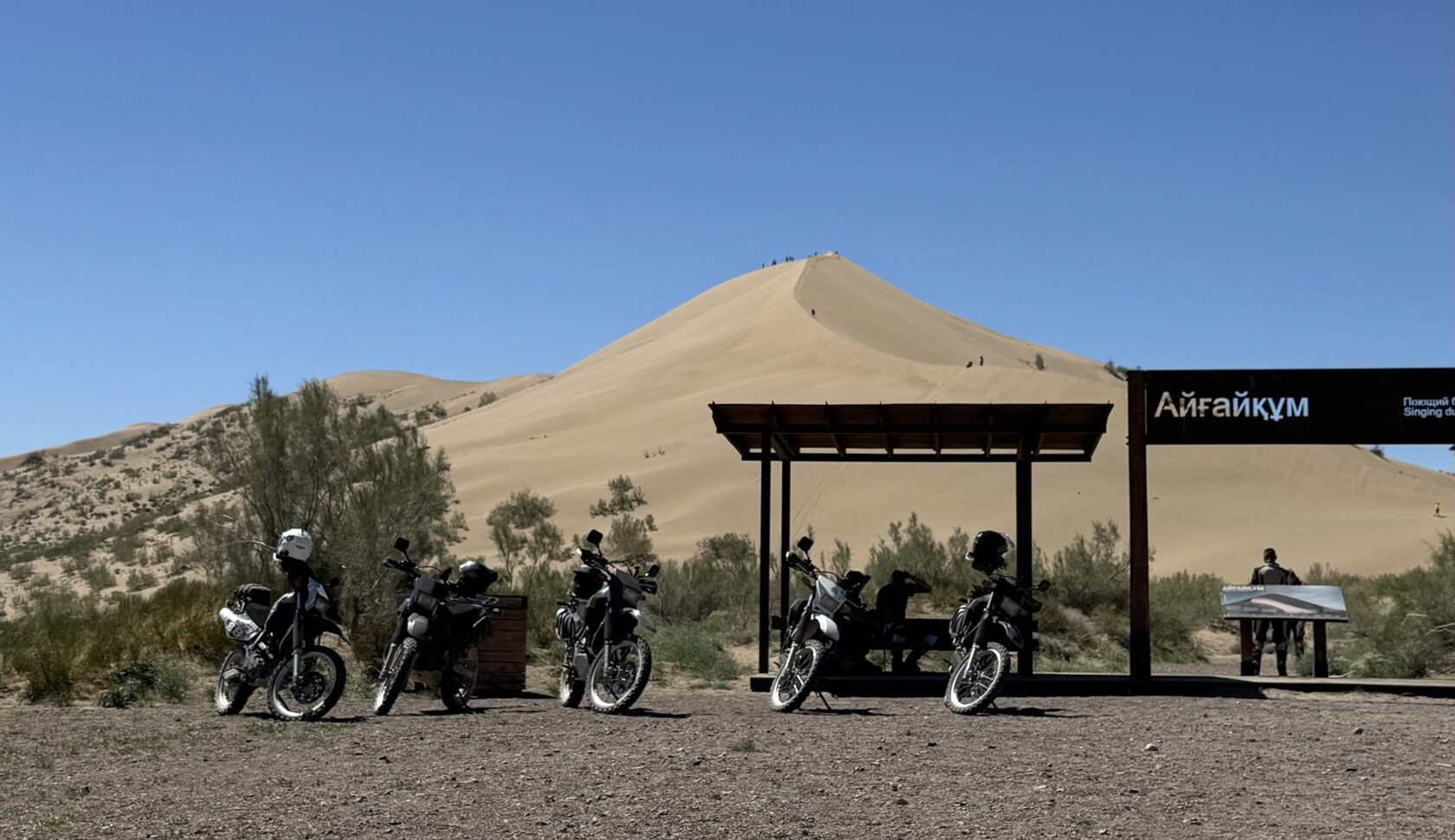 Suzuki DR650SE motorcycles parked under the Singing Dune, Altyn-Emel National Park, Kazakhstan