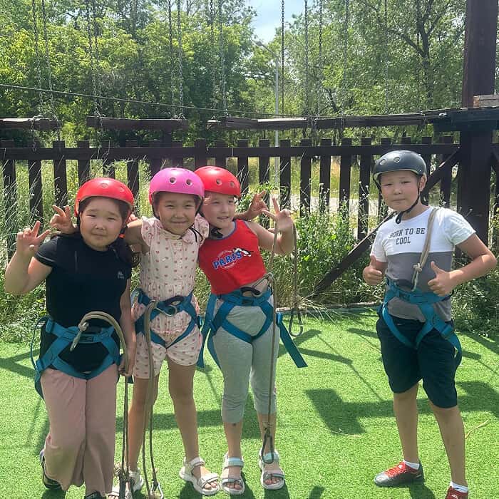 Шлемдегі және арқандармен жүруге арналған жабдықтағы балалар