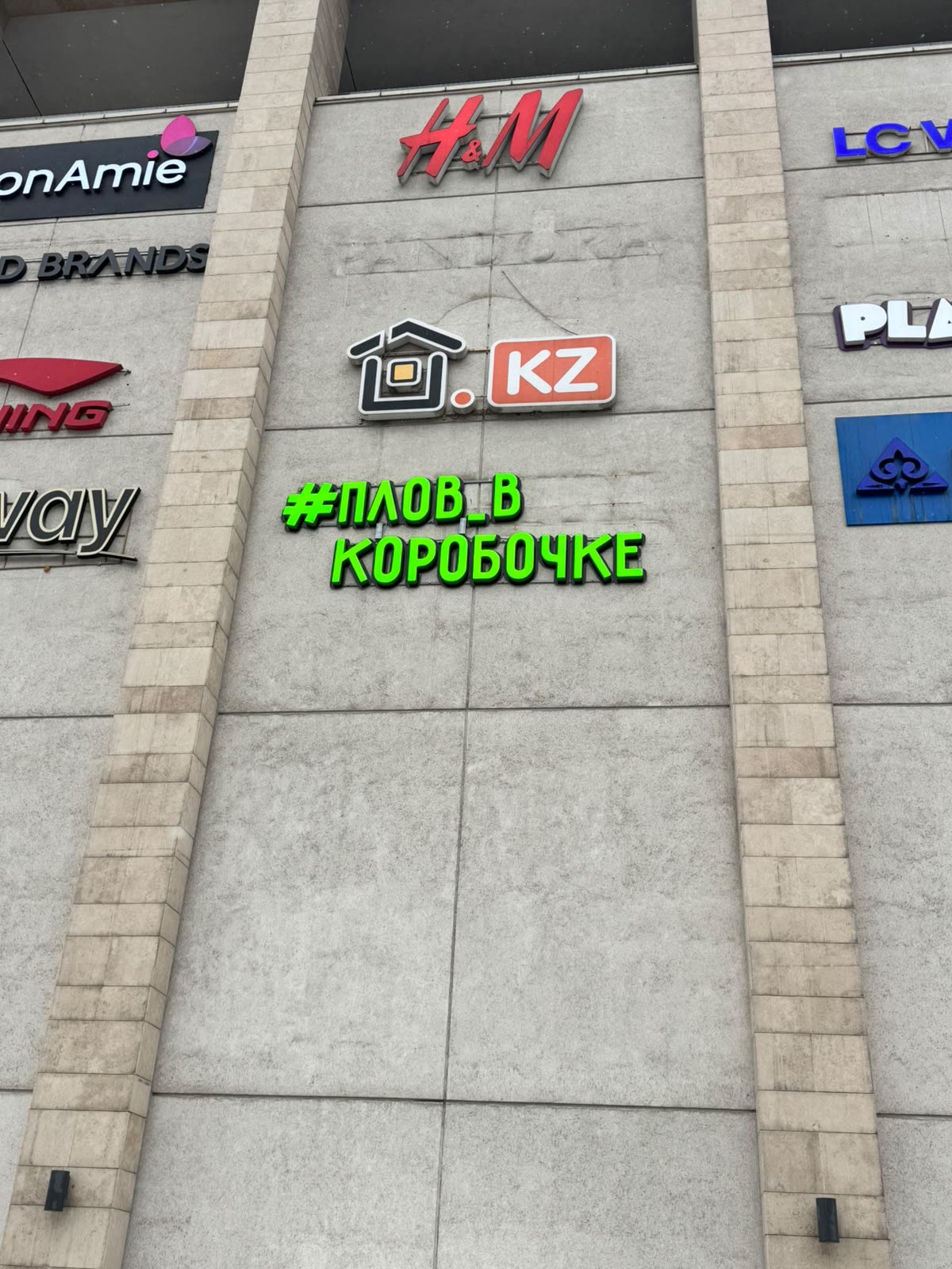 Вывеска Плов в коробочке — зелёные световые буквы на фасаде ТРЦ