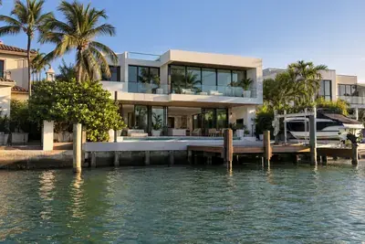 Modern waterfront home with a seawall and dock on a Miami canal