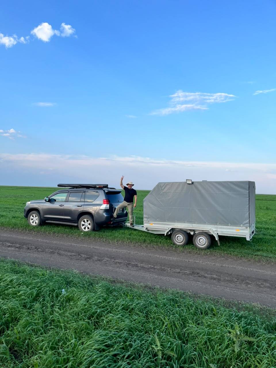 Внедорожник и прицеп-фургон у поля