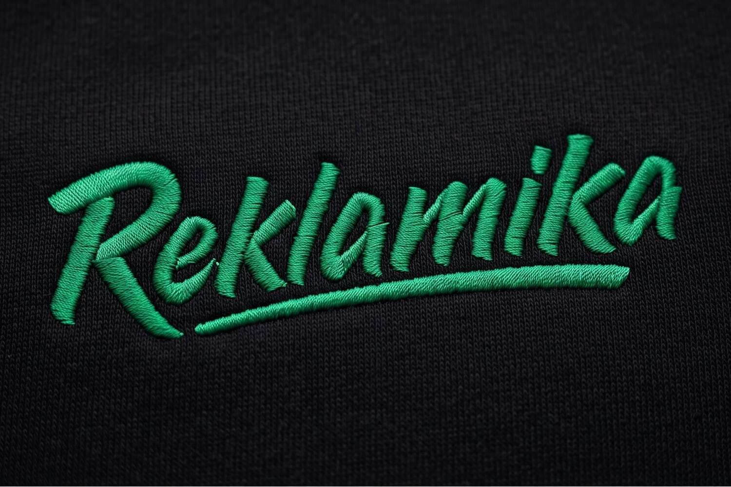 Машинная вышивка логотипа Reklamika зелёной нитью на чёрном свитшоте